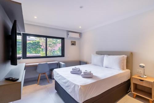 a bedroom with a bed and a desk and a window at 360 Liberdade in Sao Paulo