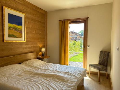 une chambre avec un lit, une fenêtre et une chaise dans l'établissement Luxueux Appartement au Centre des Gets avec Jardin, Proche Pistes, 3 Chambres, Wi-Fi, Parking - FR-1-623-338, aux Gets