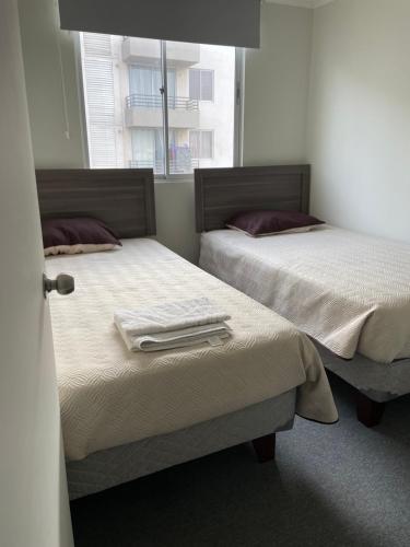 2 Betten nebeneinander in einem Zimmer in der Unterkunft Departamento Vista Aeropuerto in La Serena