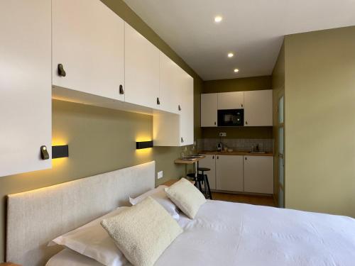 Cet appartement comprend une chambre avec un lit blanc et une cuisine. dans l'établissement My Little Home - Le Vieux Lille de St Etienne, à Lille