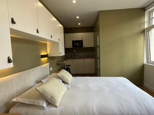 une chambre avec un grand lit blanc avec deux oreillers dans l'établissement My Little Home - Le Vieux Lille de St Etienne, à Lille