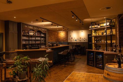 a restaurant with a bar with stools and shelves at Landgasthaus Gieseke-Asshorn in Bohmte