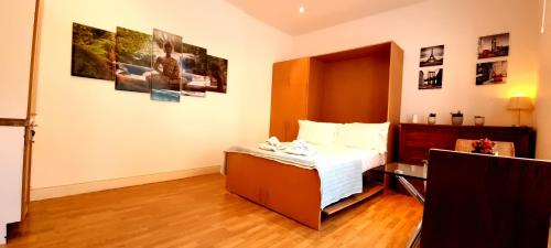 - une chambre avec un lit dans une pièce avec des photos sur le mur dans l'établissement Studio Apartment South Kensington, à Londres