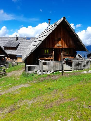 eine große Holzscheune mit einem Zaun davor in der Unterkunft Rauterhof in Hermagor