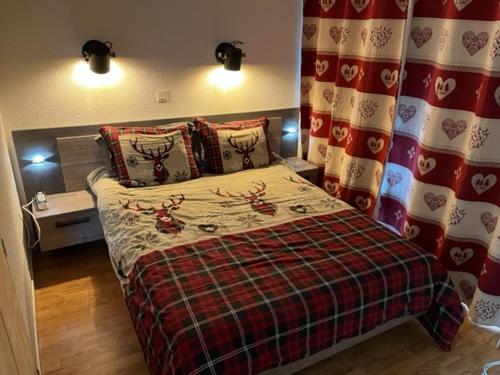 a bedroom with a bed with a plaid comforter at Le chalet d'Isis in Villarodin-Bourget