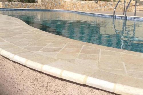 una piscina con una pasarela de piedra junto a ella en Spacious Villa With a Pool, en Nea Peramos