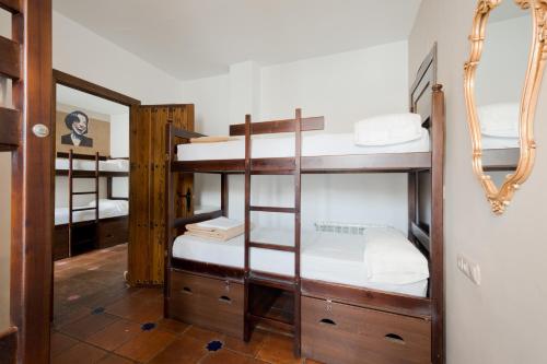 a room with four bunk beds with a mirror at Oasis Backpackers' Hostel Granada in Granada