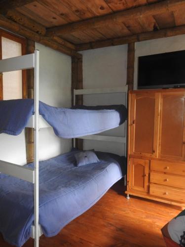 een slaapkamer met 2 stapelbedden en een tv bij Refugio ecológico Villa Mercedes in San Antonio del Tequendama