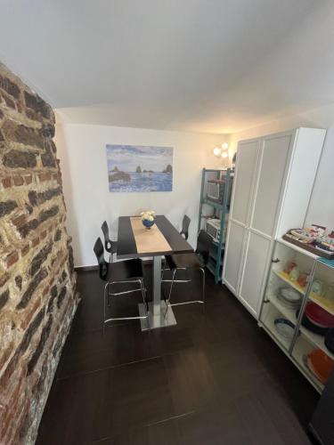 une salle à manger avec une table et un mur en briques dans l'établissement Amuri di casa Scogliera, à Catane