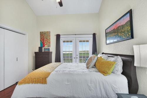 a bedroom with a bed with white sheets and yellow pillows at Cozy Glimmer in Canyon Lake