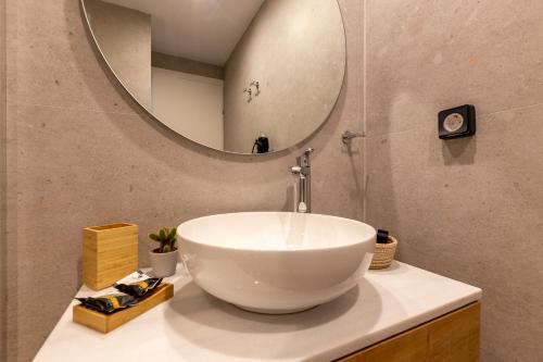 W łazience znajduje się umywalka i lustro. w obiekcie Mandevilia Suites w Atenach