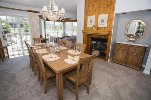 a dining room with a table with chairs and a fireplace at The Earnest at Ships Watch in Duck