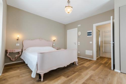 a bedroom with a white bed and a wooden floor at Il cantuccio sul Garda - Relais di charme in Cavaion Veronese