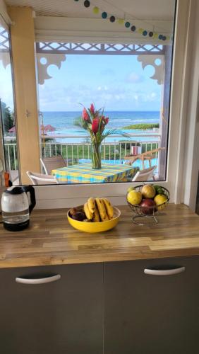 - un bol de fruits sur un comptoir devant une fenêtre dans l'établissement Kaz Loriké - Vue Mer & piscine exceptionnelle - Anse des Rochers, à Saint-François
