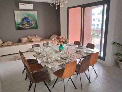 a dining room table with chairs and a large window at Aquaview Amina's rental apartment in Bijilo