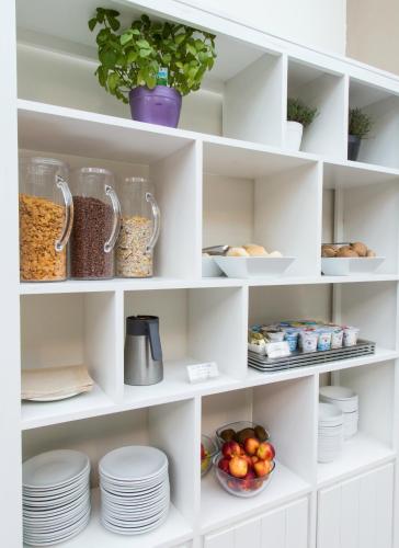 a white pantry with plates and bowls of food at Best Western Hotel Anthurium in Santo Stefano al Mare