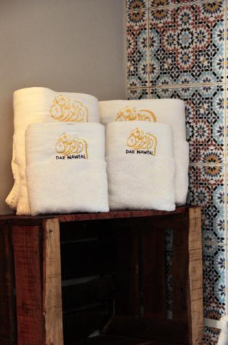 a pile of towels sitting on top of a shelf at Riad Dar Nawfal in Sale