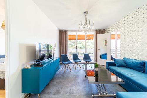 een woonkamer met een blauwe bank en blauwe stoelen bij Appartement spacieux 8 pers avec balcon Bron in Bron