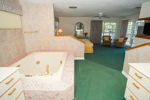 a bathroom with a bath tub and a bedroom at The Merimoth at Ships Watch in Duck