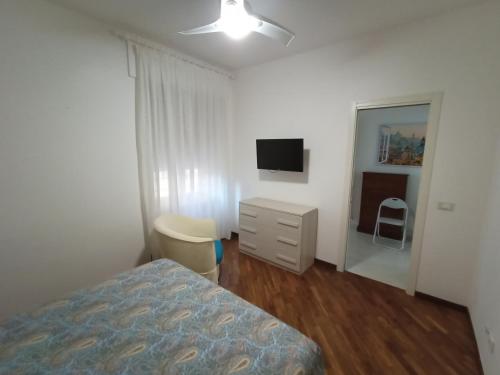 una camera con letto, cassettiera e televisore di Appartamento Stella Polare a Lido di Ostia