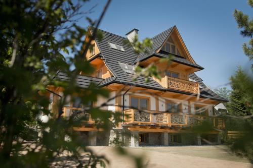 a large wooden house with a gambrel roof at Villa 11 Folk & Design in Zakopane
