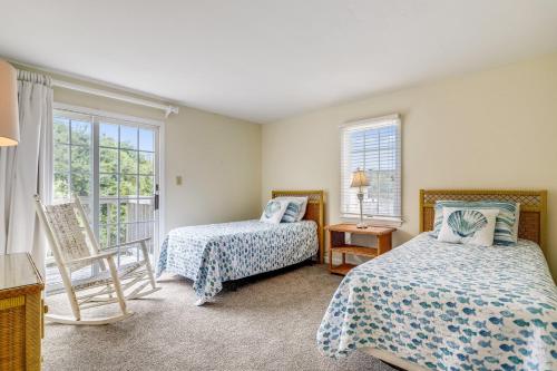 una camera da letto con due letti, una sedia e finestre di The Taylor at Ships Watch a Duck