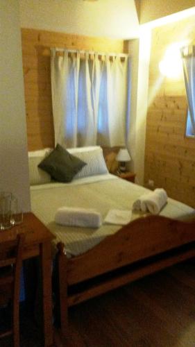 a bedroom with a large bed with a blue curtain at Locanda Aquila Bianca in Valprato Soana