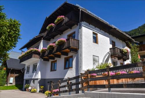 una casa blanca con flores en los balcones en Haus Binder, en Weissensee