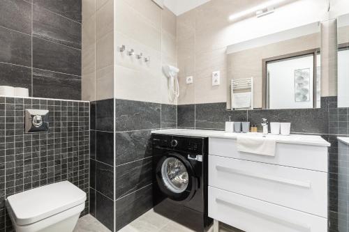 un bagno con lavatrice e asciugatrice di Chill 'N' Joy Boutique suites a Budapest