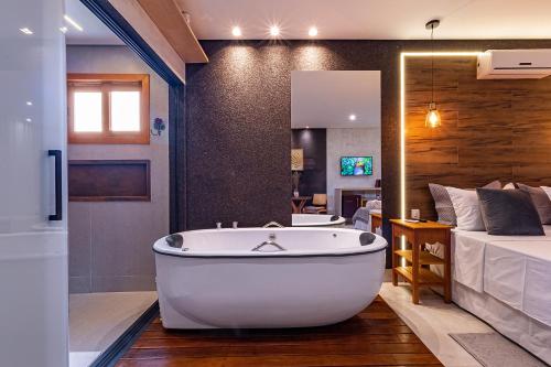 - Baño con bañera junto a la cama en Pousada Villa Mariana, en Pirenópolis