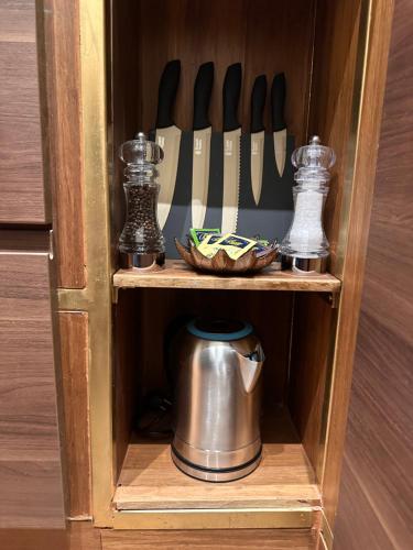 a wooden cabinet with a tea pot and knives at Maison d'Or in Genova