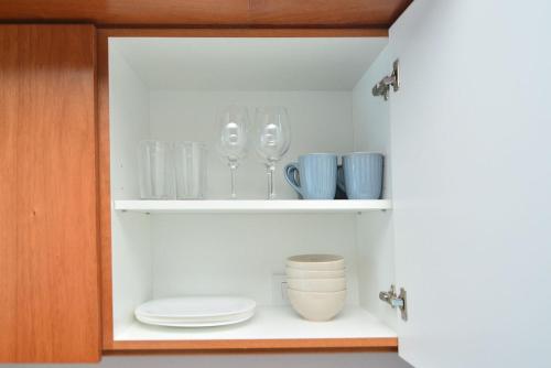 un armario con platos, tazones y vasos. en Esmeralda 1061-204 en Buenos Aires