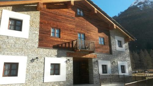 a house with a balcony on the side of it at Locanda Aquila Bianca in Valprato Soana