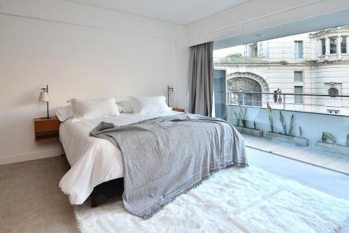 1 dormitorio con cama y ventana grande en Esmeralda 1061-204 en Buenos Aires