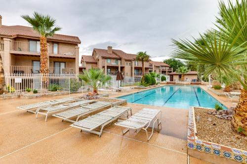 a swimming pool with lounge chairs and palm trees at Modern Condo in St Georges Sports Village in St. George