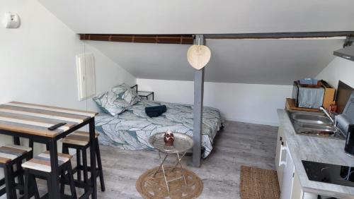 una camera con letto e tavolo e una cucina di PROMISE' LANDES a Saint-Paul-lès-Dax