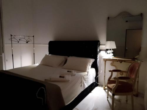 a bedroom with a bed and a chair and a lamp at PALAZZO NOVECENTO Rooms in Lecco