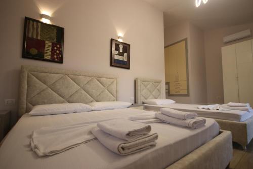 two beds in a room with towels on them at Vila Mario Himare in Himare