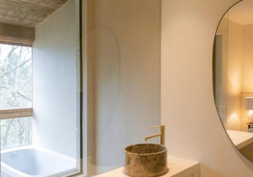 a bathroom with a tub and a sink and a mirror at Numa Experimental in Pontevedra
