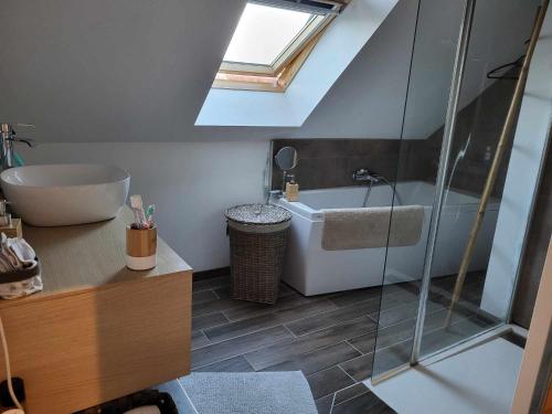 a bathroom with a tub and a sink and a shower at L'instant présent - Chambre Ambre in Salbris