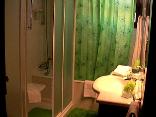 a bathroom with a green shower curtain and a sink at Villa São Paulo in Funchal