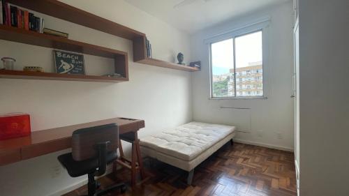 um pequeno quarto com uma secretária e uma janela em Amplo e iluminado apartamento na Gávea no Rio de Janeiro