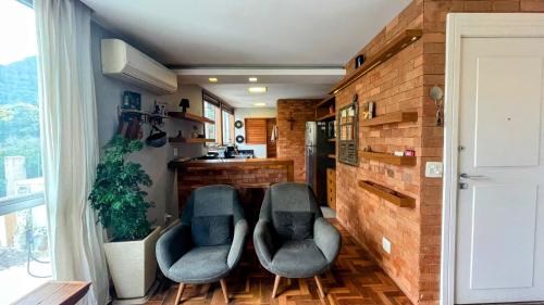uma sala de estar com duas cadeiras e uma cozinha em Amplo e iluminado apartamento na Gávea no Rio de Janeiro