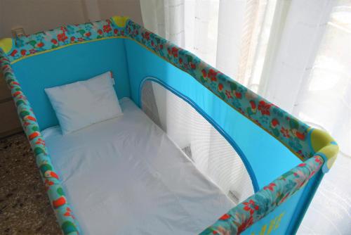 a blue crib with a pillow in a window at Gianna Seaside in Koutsounari
