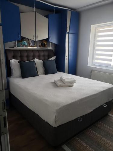 Un dormitorio con una cama grande con paredes azules. en Apartament 2 Camere, en Roman