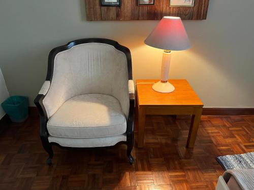 a chair sitting next to a table with a lamp at Sevenseas Marina Crescent in Port Dickson
