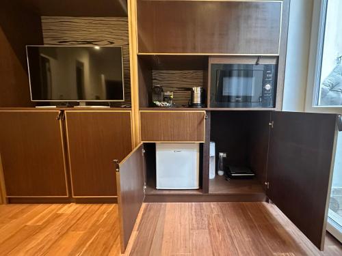 a kitchen with a microwave and a tv in a cabinet at Maison d'Or in Genova
