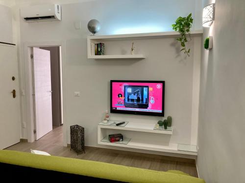 a living room with a tv on a white wall at Casa Semplice in Taranto