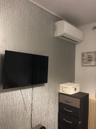 un téléviseur à écran plat accroché au mur dans l'établissement Chambre privée confortable à louer chez l habitant proche plage et centre ville de Nice, à Nice