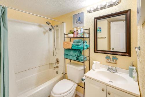 a bathroom with a toilet and a sink and a mirror at Beachfront Corpus Christi Condo with Pool Access! in Corpus Christi